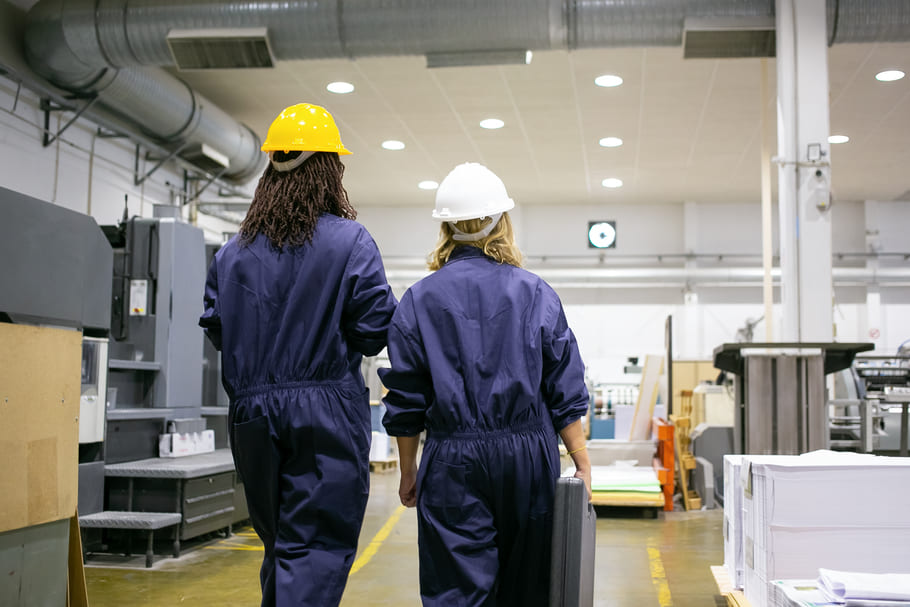 female-factory-workers-hardhats-overalls-walking-plant-floor-talking-carrying-toolkit-box (1) (1).jpg